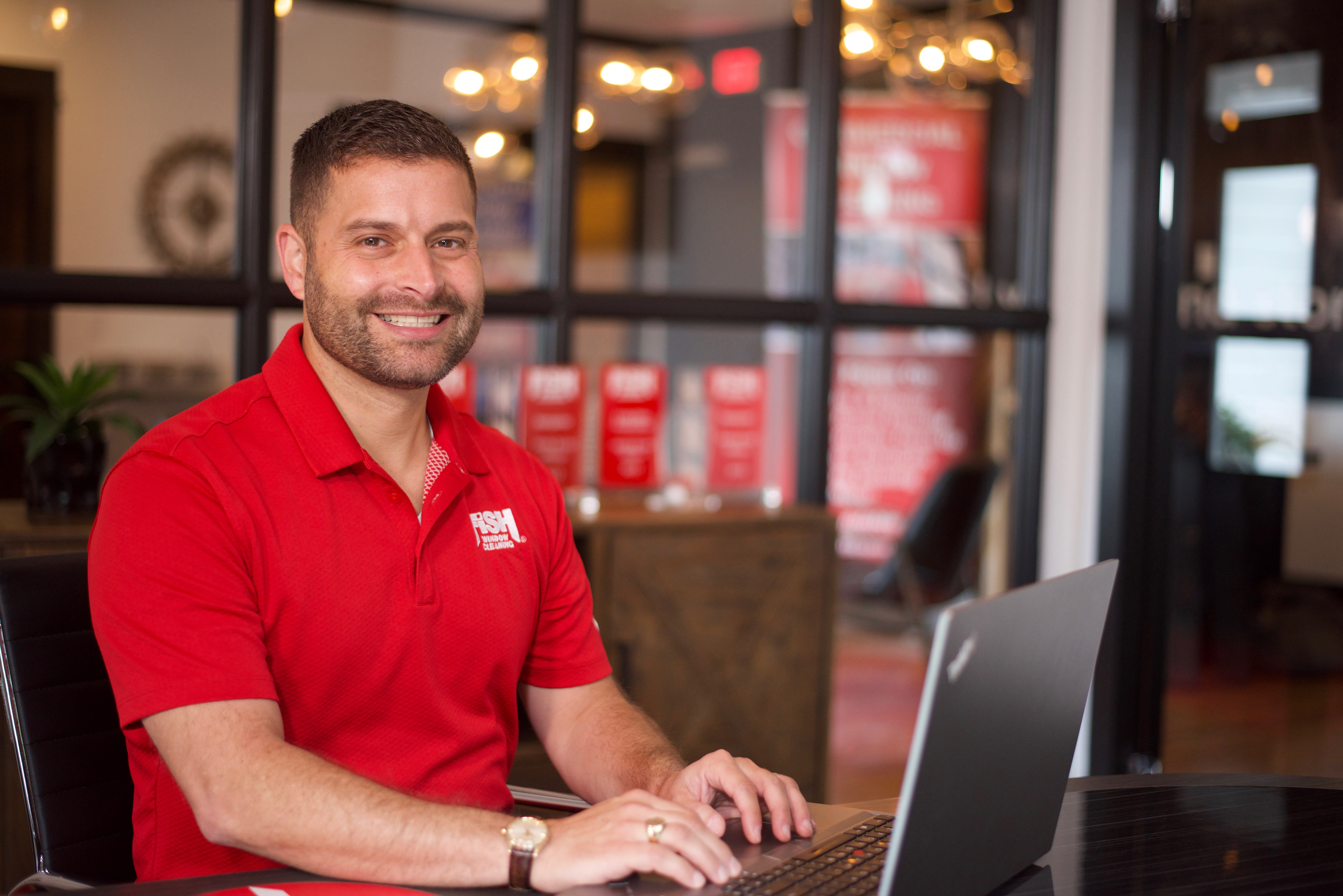 Fish Window Cleaning Franchisee Sitting at a Laptop